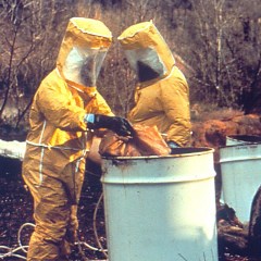 hazardous waste workers sampling a drum